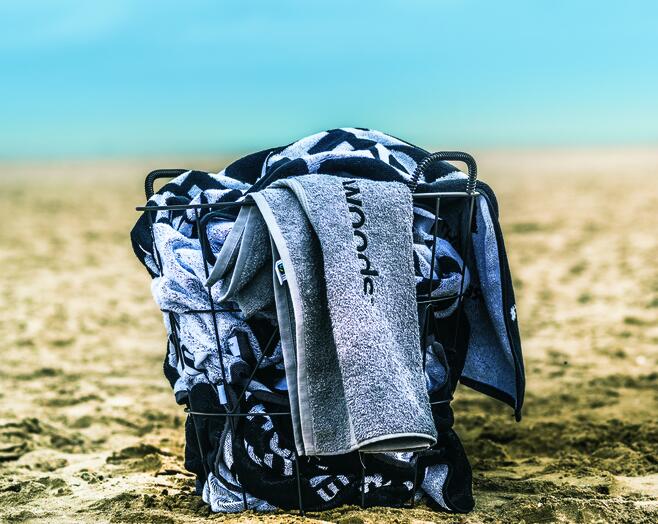Grijze handdoeken in een mand op het strand